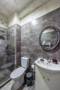 a bathroom with a toilet and a sink and a mirror at Apartament Nacis in Mamaia Sat/Năvodari