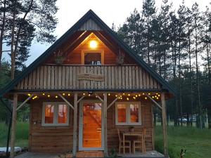 a log cabin with a light on the top of it at Pod Czarnym Dzięciołem - dom z widokiem i prywatną balią in Mazówki