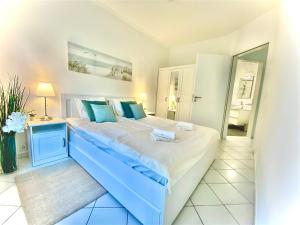 セゲドにあるMirell Apartmanの大きな白いベッドと青い枕のある寝室 +14枚の写真