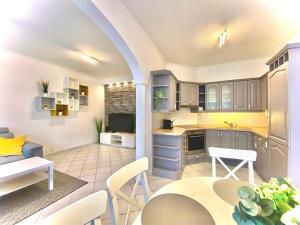 eine offene Küche und ein Wohnzimmer mit einem Tisch und Stühlen in der Unterkunft Mirell Apartman in Szeged