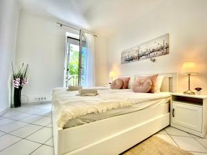 a white bedroom with a large bed in a room at Mirell Apartman in Szeged