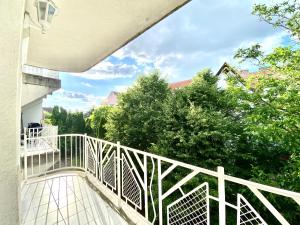 a balcony with a white railing and trees at Mirell Apartman in Szeged