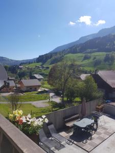 a balcony with a table and chairs and a valley at Gîte de la snaille in Le Reposoir