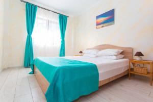 a bedroom with a bed with a blue blanket on it at Sorriso Mamaia Nord in Mamaia Sat/Năvodari