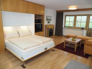 a bedroom with a bed and a living room at Appartmenthaus Moos Bäu in Lam