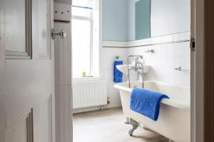 a white bathroom with a tub and a sink at BELLE VUE - SKIPTON in Skipton