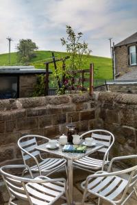a table and chairs on a patio with a stone wall at BELLE VUE - SKIPTON in Skipton