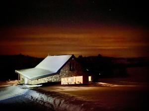 ein Gebäude mit einem schneebedeckten Dach in der Nacht in der Unterkunft Hacienda na Orave in Novoť