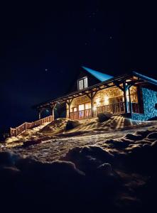ein Blockhaus leuchtet nachts in der Unterkunft Hacienda na Orave in Novoť