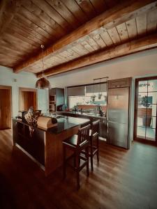 a kitchen with a large island with chairs in it at Hacienda na Orave in Novoť