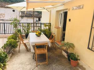 eine Terrasse mit Tisch und Stühlen und einem Sonnenschirm in der Unterkunft Ca Àngela in Bolulla