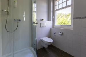 a bathroom with a toilet and a shower and a window at Strandläufer 04 in Ahrenshoop