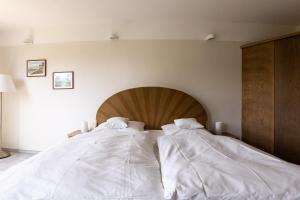 two white comforters on a bed in a bedroom at Muschel 4 in Ahrenshoop