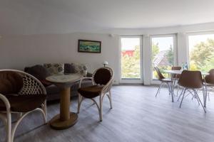 a living room with a couch and a table and chairs at Muschel 4 in Ahrenshoop