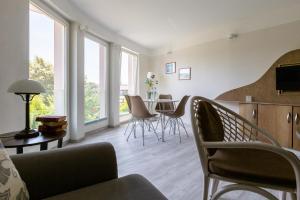 a living room with a couch and a table with chairs at Muschel 4 in Ahrenshoop