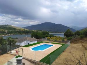 uma imagem de uma piscina com vista para um lago em El Mirador Apartamentos em El Barraco