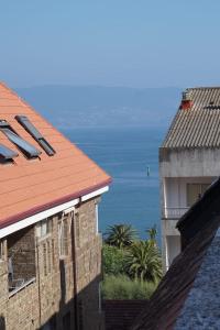 a view of the ocean from between two buildings at La Placita, Sanxenxo in Sanxenxo