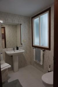 a bathroom with a sink and a toilet and a window at La Placita, Sanxenxo in Sanxenxo