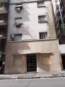 a building with a door in the middle of a street at DTO 1AMB. RECOLETA in Buenos Aires