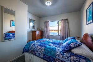 a bedroom with a bed and a window at 11b Leamington Street in Hanmer Springs