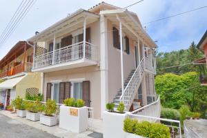 a white house with white balconies and plants at Yia Sou Corfu! "Kolibri" in Sinarádes