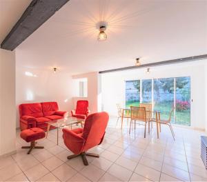 sala de estar con sillas rojas y mesa en Maison des bains - 3 chambres - Jardin - Wifi, en Valence-dʼAgen