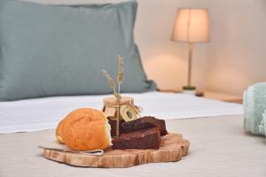 a tray with cake and a loaf of bread on a bed at Yia Sou Corfu! "Kolibri" in Sinarádes