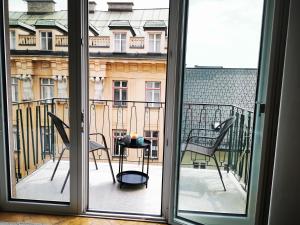 a view from a window of a balcony with chairs at Charmante Zentrumswohnung mit Balkon und 80 zoll TV in Klagenfurt +35 photos