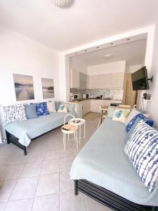 sala de estar con 2 sofás y cocina en A wonderful apartment in front of the sea!, en Perea
