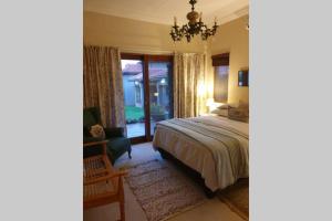 a bedroom with a bed and a chair and a window at 66 Sharalumbi Wildlife Estate in Lydenburg