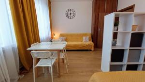 a small room with a table and chairs and a couch at Apartament Orzysz "Żabi Staw" in Orzysz