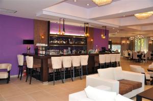 bar w restauracji z białymi stołkami barowymi w obiekcie Amalias Hotel w mieście Kourouta