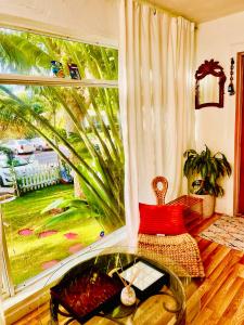 een kamer met een glazen tafel en een groot raam bij Ne Miami Cottage in Miami