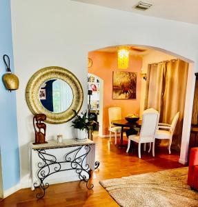een woonkamer met een tafel en een spiegel bij Ne Miami Cottage in Miami