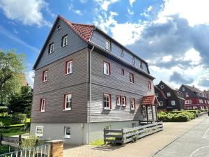 une grande maison grise avec un toit rouge dans l'établissement Landhaus Wiesengrund, à Braunlage