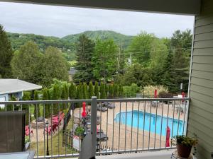 balcón con vistas a la piscina y a las montañas en Le Champlain Condo-Hôtel, en Bromont
