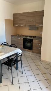y cocina con mesa, sillas y fogones. en San Teodoro centro, en San Teodoro