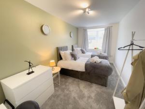 a bedroom with a bed and a window at Spacious Contractor Flat for Large groups - Private Parking by Tailored Apartments in Cheshunt