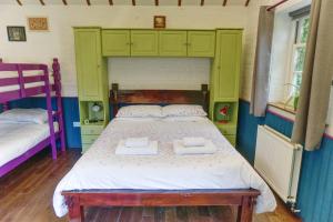 a bedroom with a bed with two towels on it at Bramble Cottage in Whiteparish