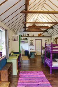 una sala de estar con muebles de color púrpura y techo de madera. en Bramble Cottage en Whiteparish