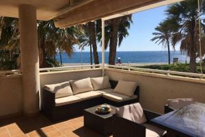 - un balcon avec un canapé et une table donnant sur l'océan dans l'établissement FRENTE AL MAR, à Castell de Ferro