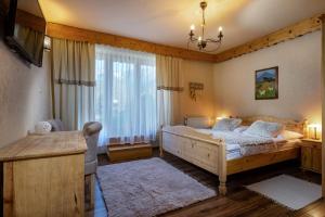 a bedroom with a bed and a large window at Penzion Enrico in Ždiar