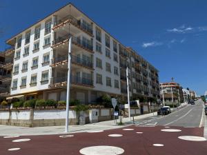 サンシェンショにあるApartamento Sanxenxo Playa Silgar 30mの通り側の白い大きな建物