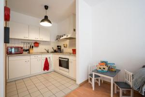 a kitchen with white cabinets and a table in a room at Große Louise in der Neustadt für Familien & Kinder in Dresden