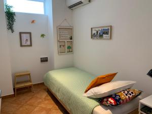um quarto com uma cama com almofadas e uma janela em Home Sweet Home VRSA em Vila Real de Santo António