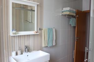 een badkamer met een wastafel, een spiegel en handdoeken bij Home Sweet Home VRSA in Vila Real de Santo António +43 foto's