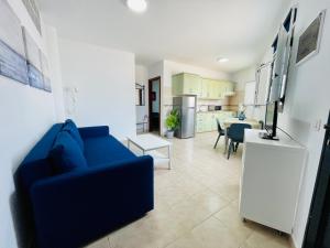 a living room with a blue couch and a kitchen at Casa Josefa 1 in Caleta de Sebo