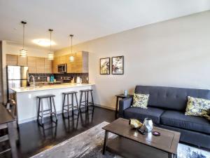 uma sala de estar com um sofá azul e uma cozinha em Modern Urban Apartments│On Roosevelt Row│Local Eat & Drink em Phoenix