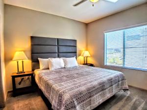 a bedroom with a bed with two lamps and a window at Modern Urban Apartments│On Roosevelt Row│Local Eat & Drink in Phoenix