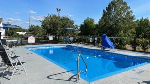 einen Pool mit Stühlen und einem blauen Pool in der Unterkunft Baymont by Wyndham Dublin in Dublin